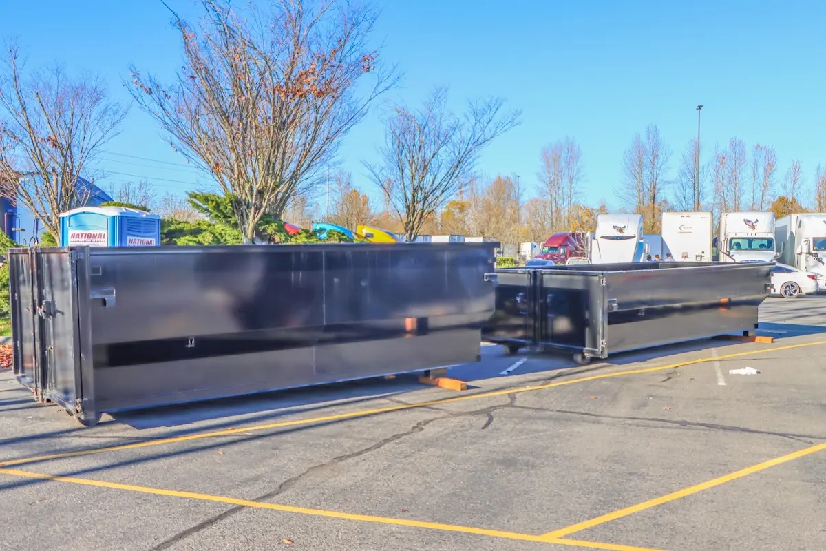 Professional dumpster rental service with roll-off container on residential driveway in Greenwood